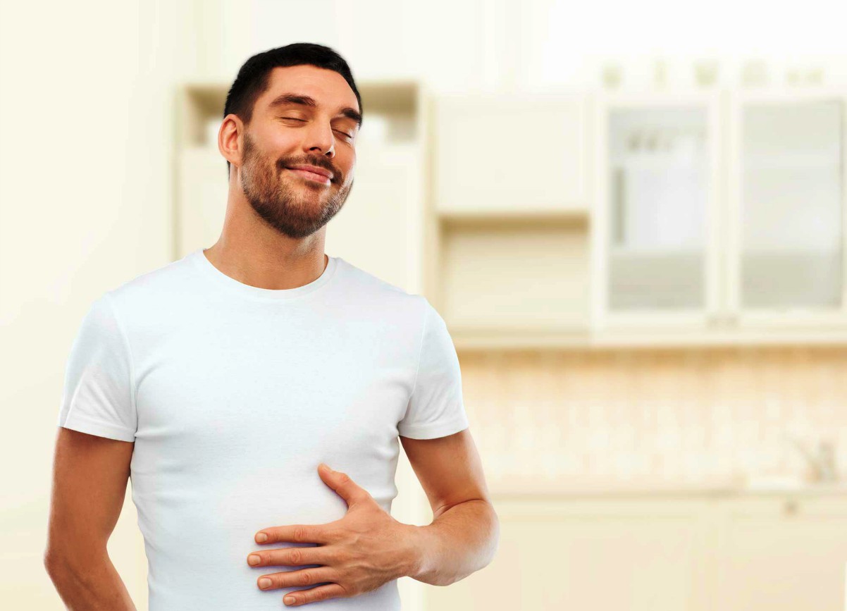 Happy full man touching his tummy over kitchen background | Enzymes… A Health Miracle? | Enzymes