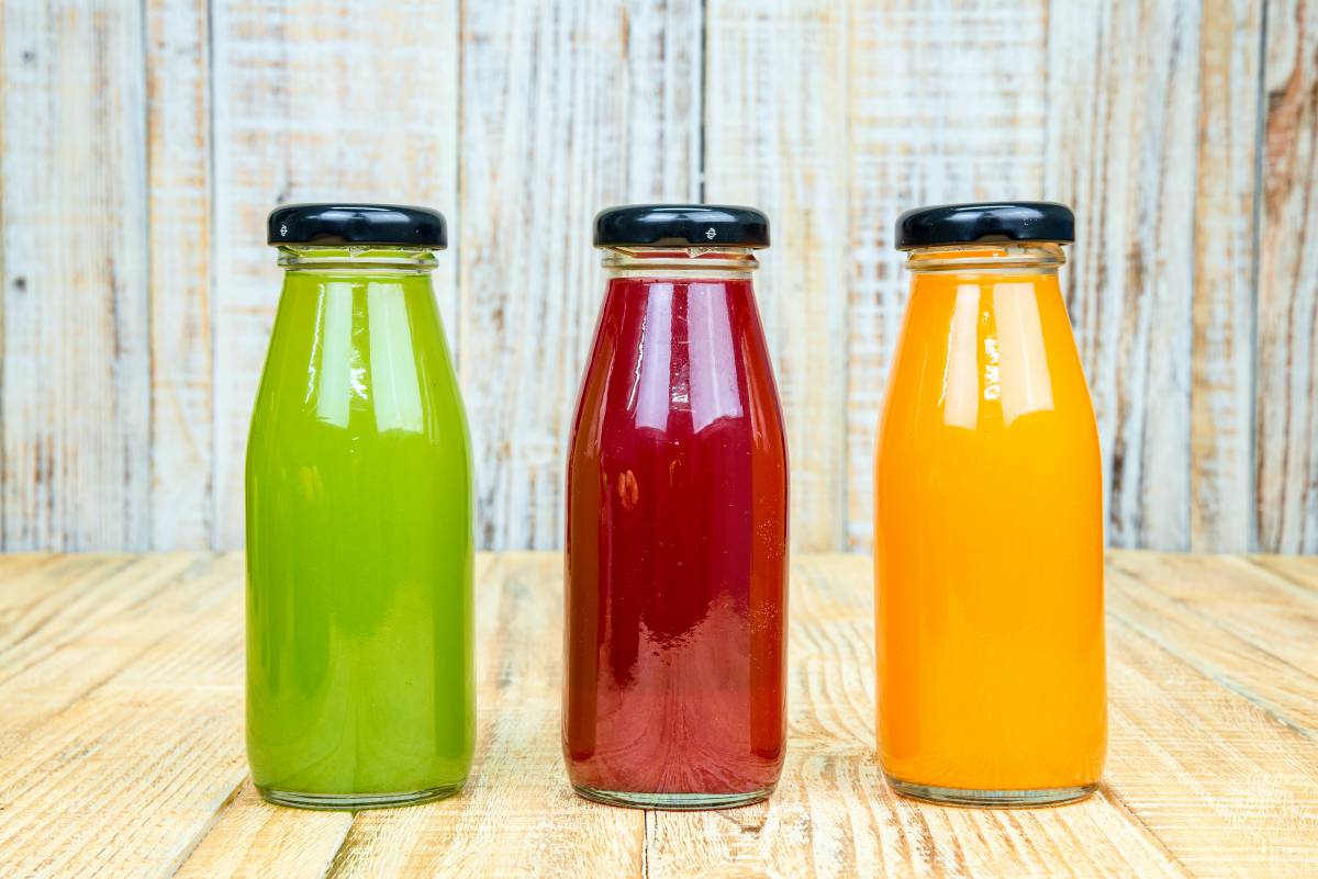 Juice bottle on vintage wooden background | Is The Fructose In Fruit Making You Fat And Sick?