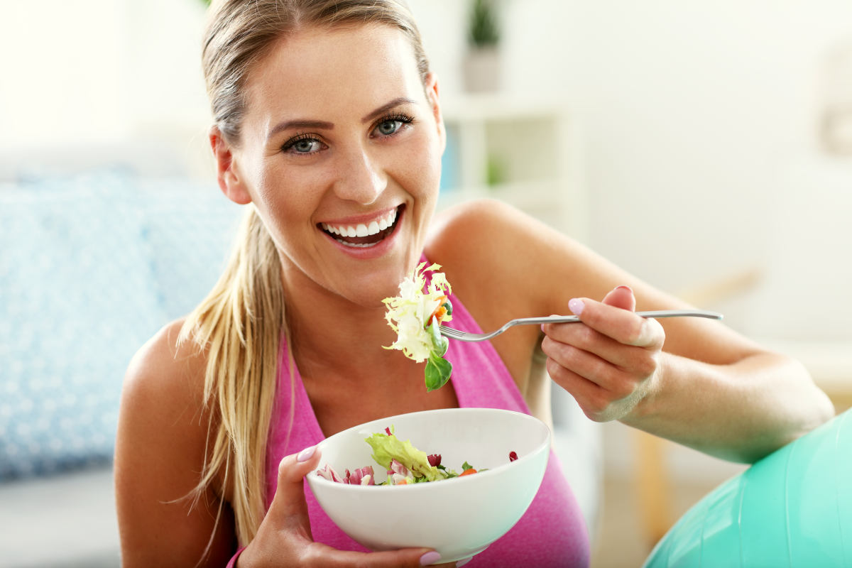 Fit woman eating healthy salad | Ways To Have A Balanced Microbiome