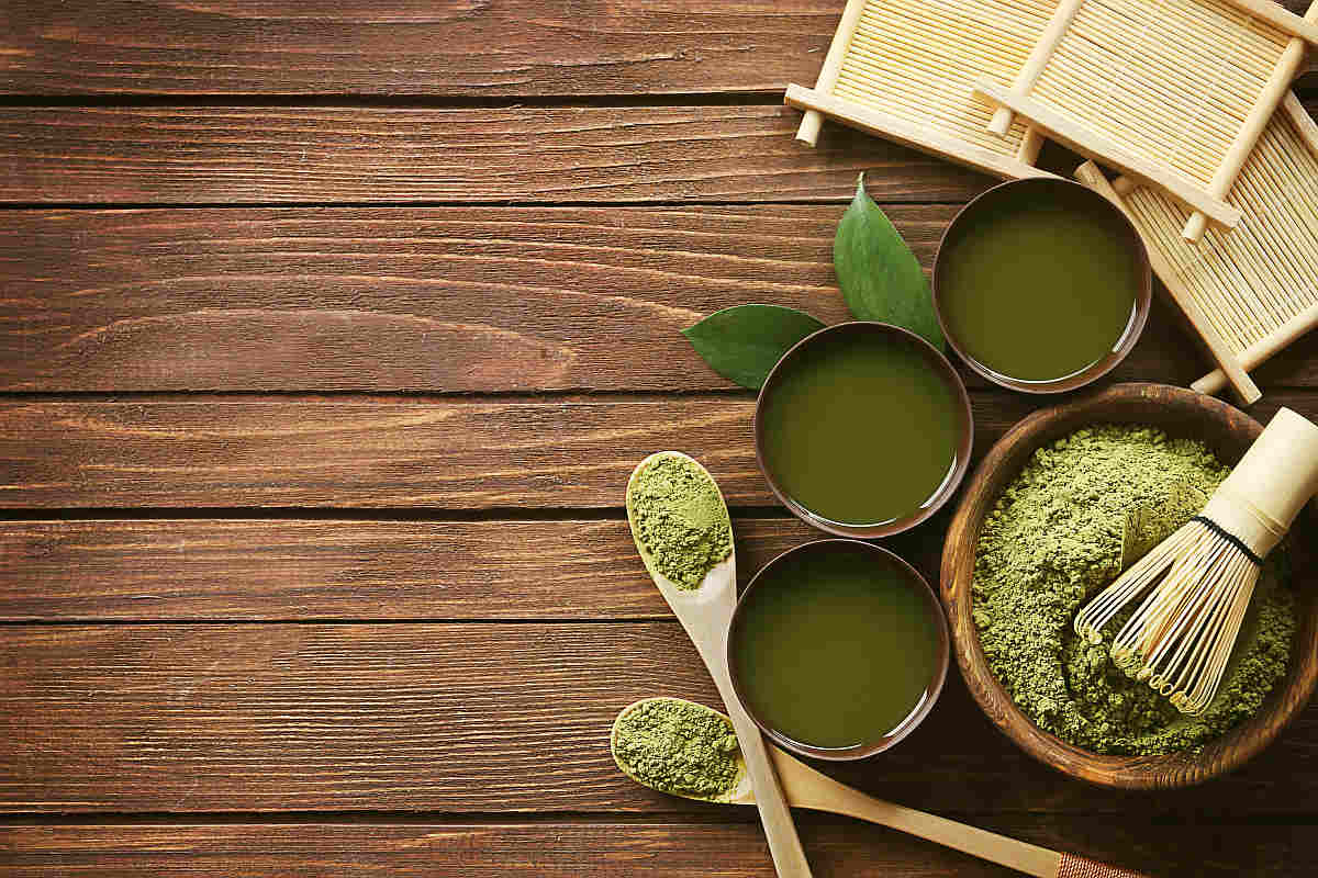 Flat lay of matcha powder and leaves on a table | The Battle Of The Greens: Moringa vs. Matcha | matcha benefits | super greens