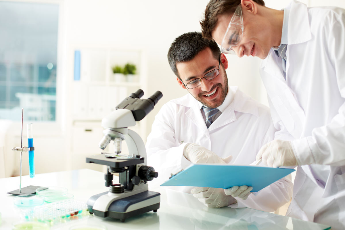 Two clinicians discussing medical document in laboratory | The Relations Between Stress, Trauma, And Autoimmune Conditions | stress