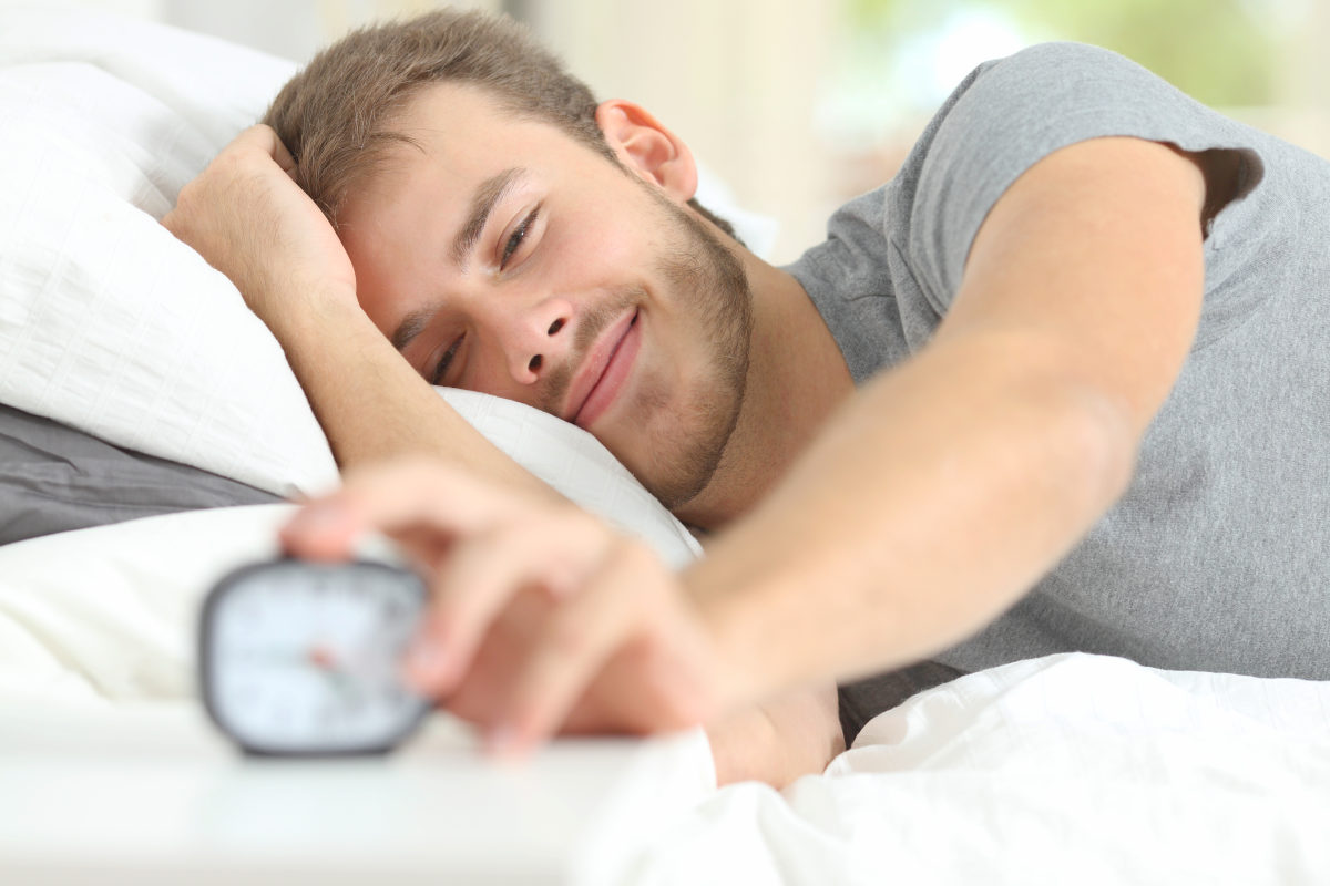 Happy wake up of a happy man lying on the bed | How A Balanced Microbiome Promotes Higher Energy Levels