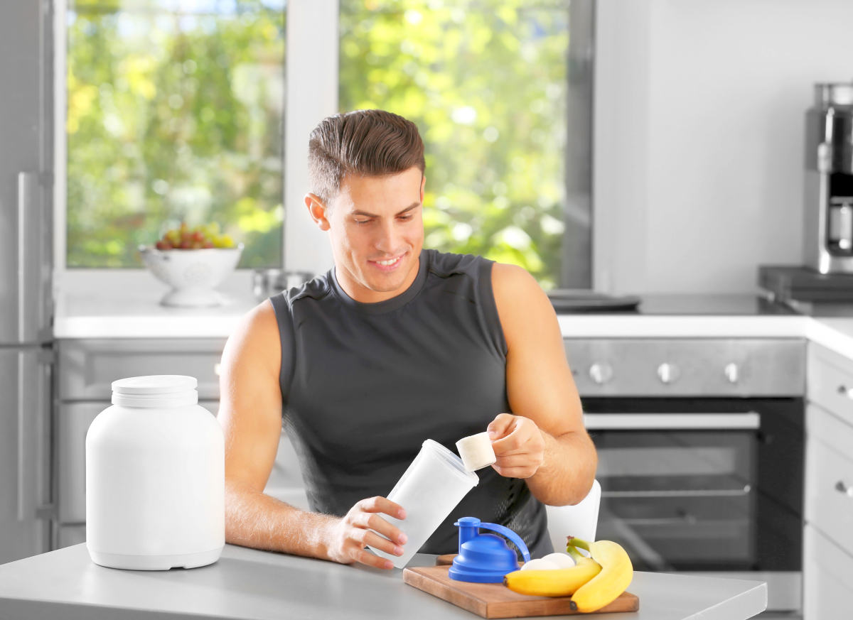 Man preparing protein shake in kitchen | Can Too Much Protein Cause Inflammation?