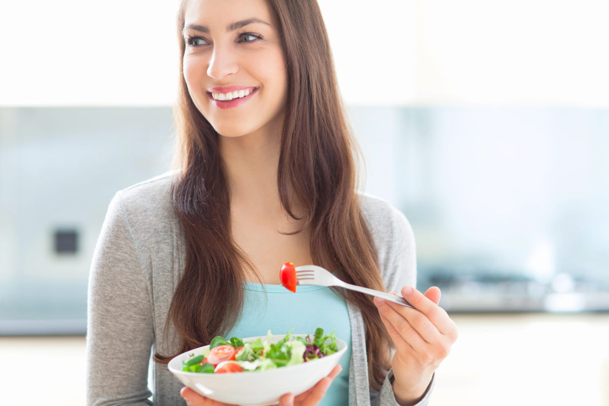 Woman eating salad | How A Balanced Microbiome Promotes Higher Energy Levels