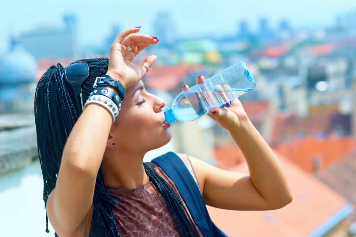 woman drinking water | How To Keep Your Gut Health Happy While Traveling | best probiotics for travel | gut healthy while traveling