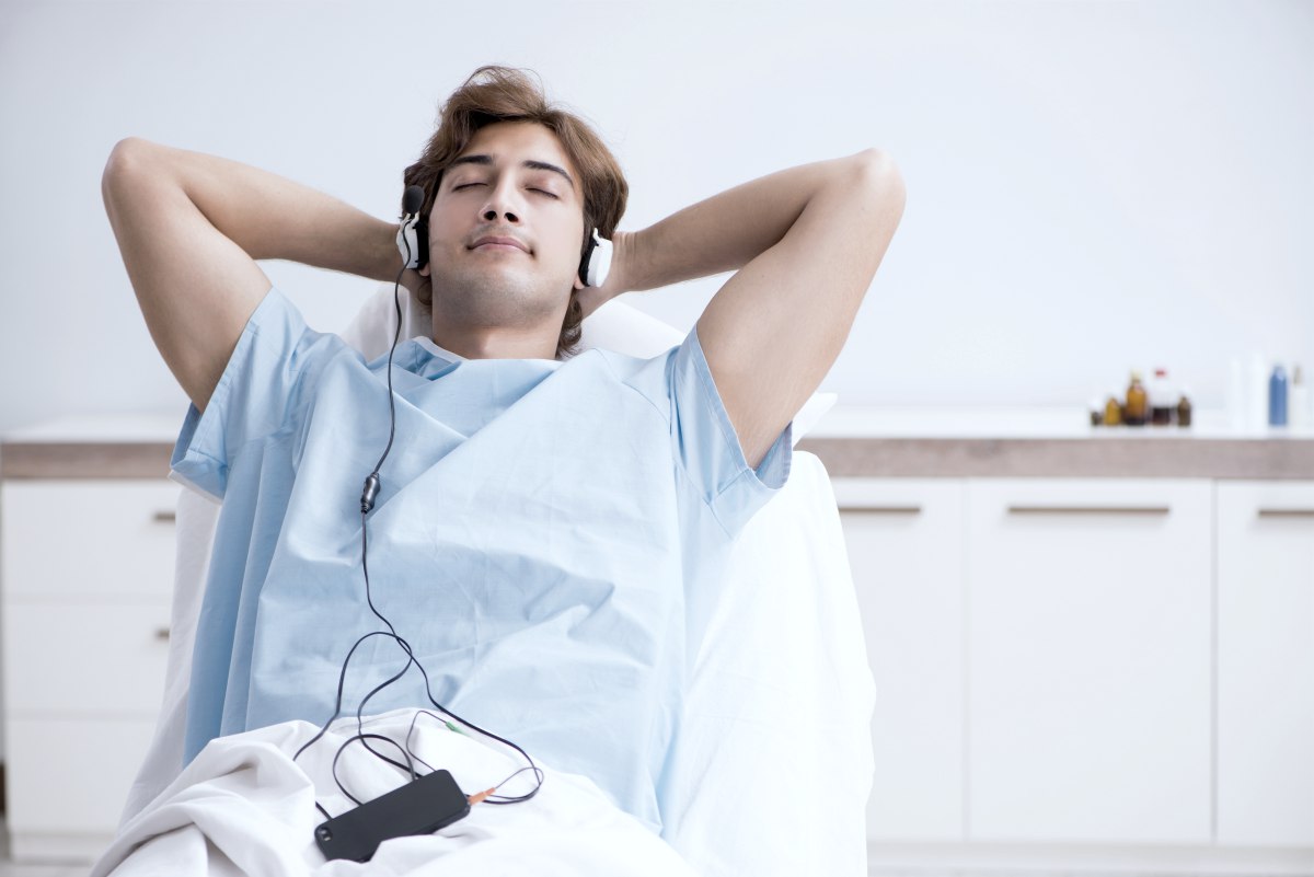 young male patient listening to music while in hospital gown and inside the room relaxing | Reasons Why Listening To Peaceful Music Is Good For Your Health peaceful sleep music